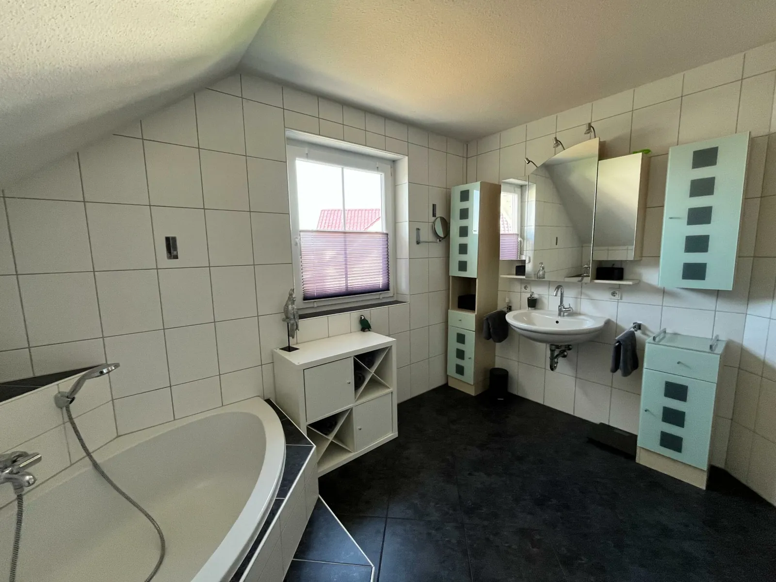 Badezimmer mit Eckbadewanne und Waschtisch