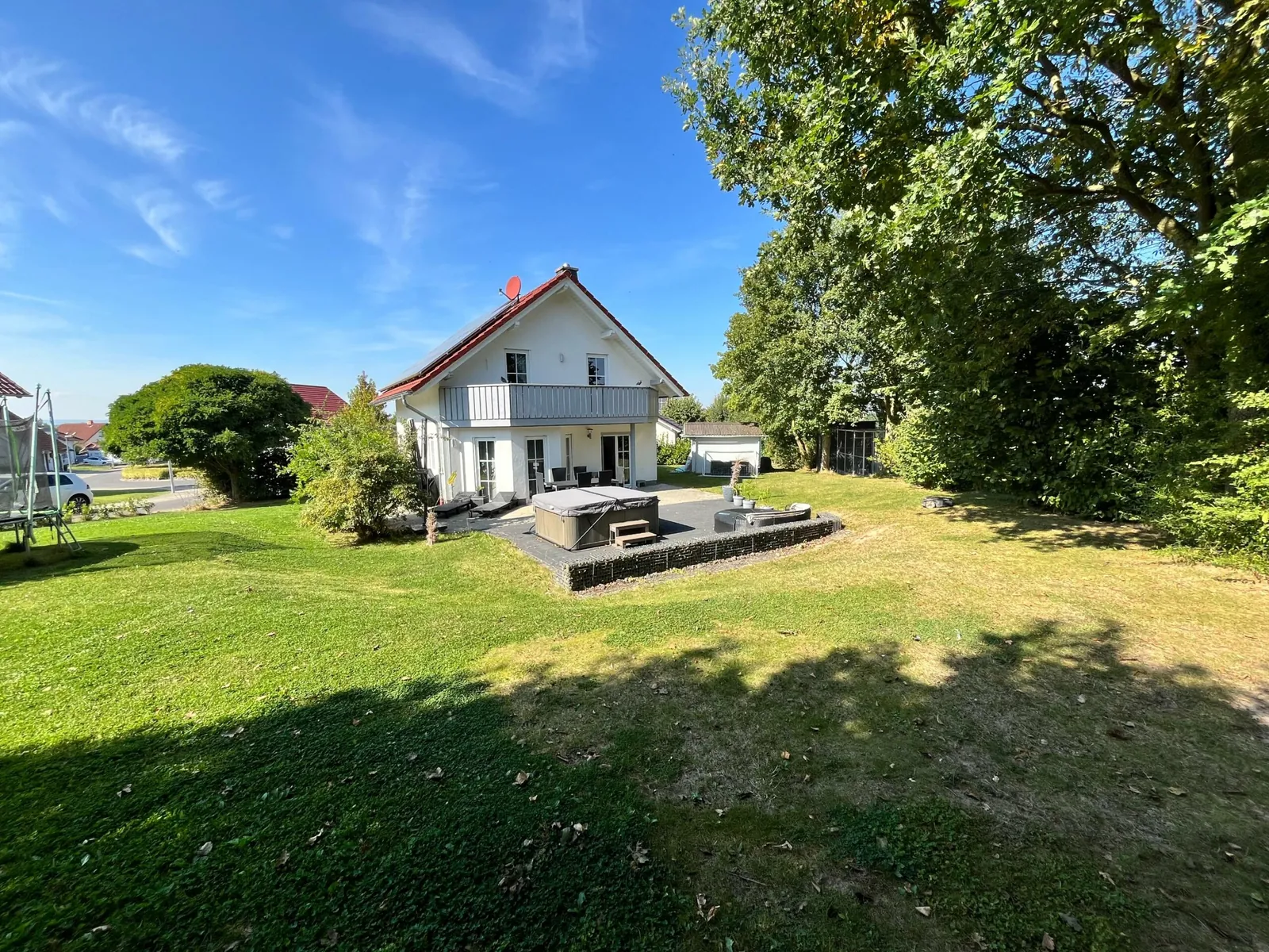 Haus mit Terrasse und großer Rasenfläche